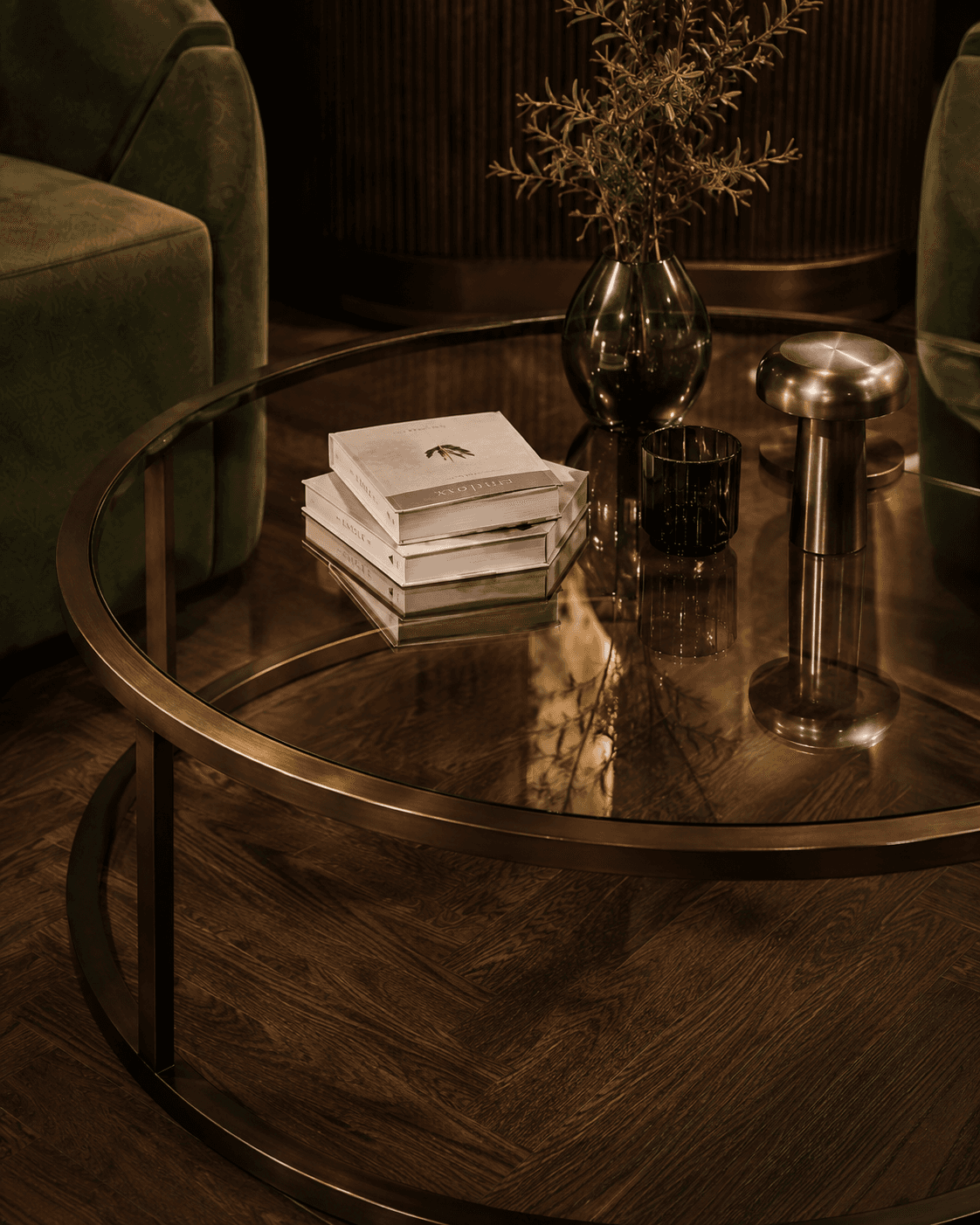 Olive Lounge Concept smoked glass table with bronze frame, walnut flooring, and warm accessories